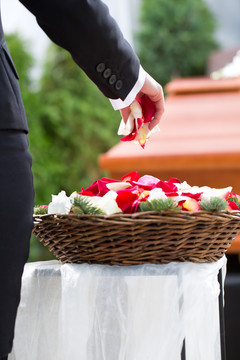 葬礼上的哀悼妇女，手持鲜花站在棺材或棺材上