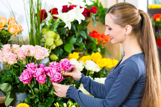 花店或苗圃里献黄玫瑰的女花匠