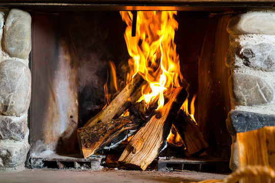 在传统山间小屋的乡村壁炉里点火