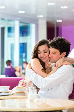 一对相爱的情侣在咖啡馆或冰淇淋店度过闲暇时间，一起拥抱亲吻