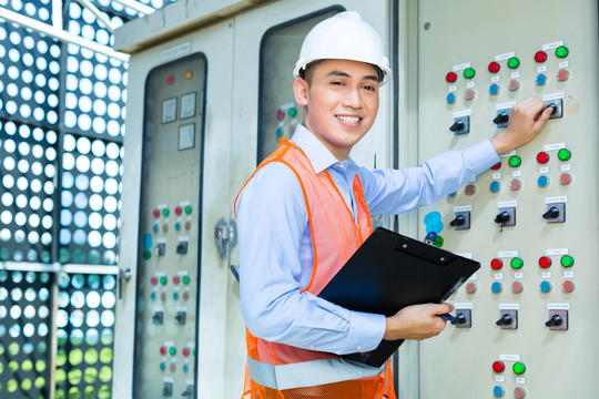 亚裔印尼技术人员或电工在施工现场或工厂对空调控制面板或开关箱进行功能测试验收