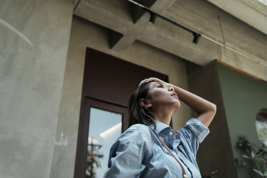 穿蓝色连衣裙的亚泰女人仰望天空-复制空间。