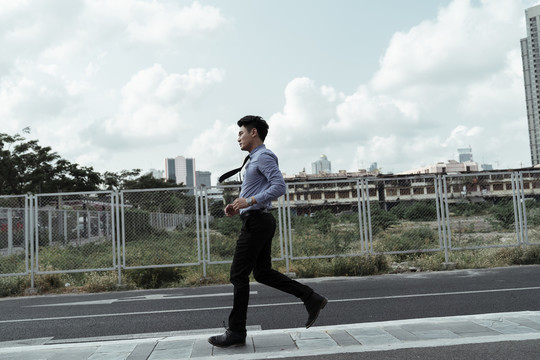 跑步的商人在上班前在路上锻炼身体。