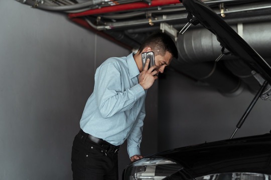 一个商人在检查完他的车后试图打电话给一个机械师，但他什么也做不了。