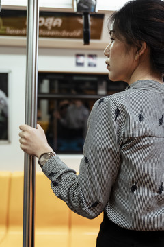 亚泰女子在火车上抓杆子，在火车上旅行。