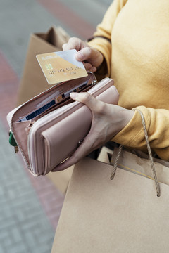 女人从钱包里拿起信用卡在购物中心使用的手。