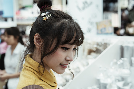 一个可爱的亚洲女人在商店里看东西的特写镜头。