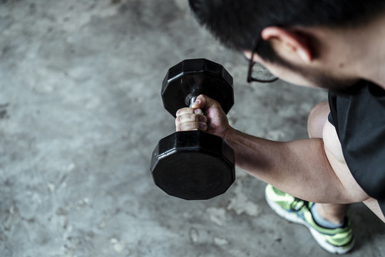运动员亚泰体育男子举行使用沉重的大哑铃在健身房。