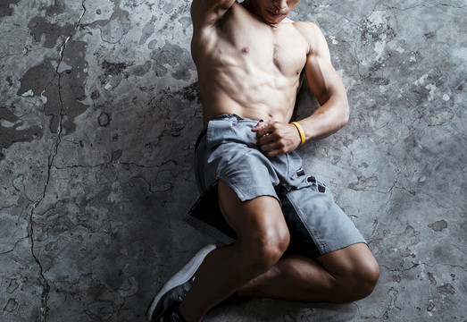 顶视图-运动员亚泰体育男子健身坐在地板上。