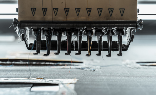 特写缝纫机和衣物，现代缝纫机。工厂机器制造服装。
