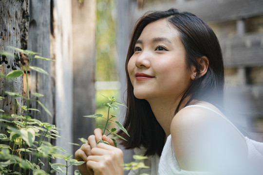 年轻美丽的亚洲女人的肖像在白色的衣服上自然。带着幸福的表情微笑。