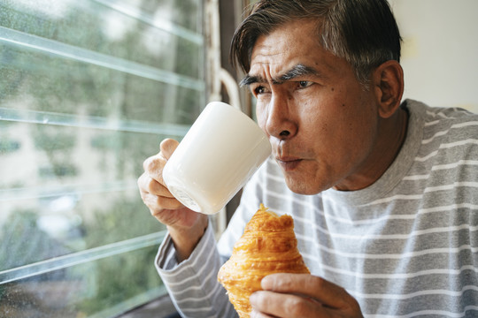 吃早饭时，兴奋的老人在屋外看着两只猫打架。