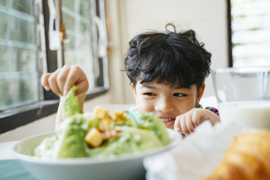 小男孩喜欢在沙拉里和cos一起吃早餐。