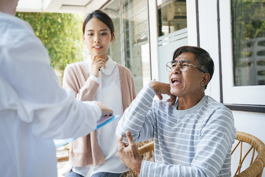 一位白发老人和他的女儿在家访时告诉医生他的病情。