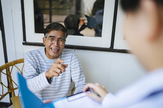 老人把自己的病情告诉了医生，并给了医生一个称赞，因为他痊愈了，她的女儿给了医生一个感激的微笑。