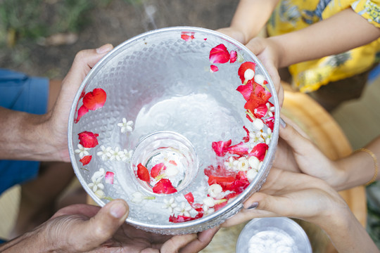 手和银碗与花水在传统的日子里的裁剪图像空中拍摄。