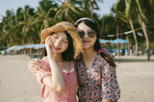 两个女孩在海滩上一起玩耍的画像。