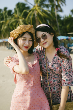 两个女孩在海滩上一起玩耍的画像。
