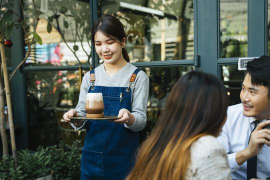 亚泰女服务员在咖啡厅为顾客提供冰镇咖啡。