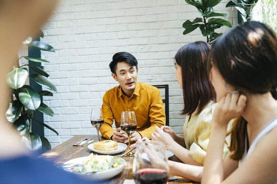 亚泰男子在餐厅与两名女子共进午餐。我请客。