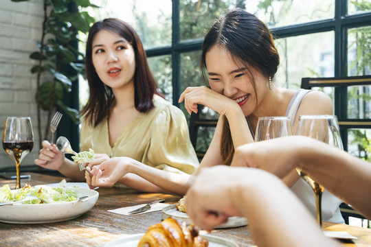 亚泰人喜欢在餐馆里一起吃饭。人们在午餐时间用酒在桌子上吃食物。