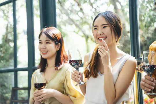 两个亚洲女人在聚会上举着酒杯。