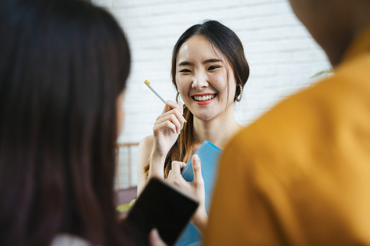 年轻的笑容灿烂的亚洲女人正在接受顾客的点菜。