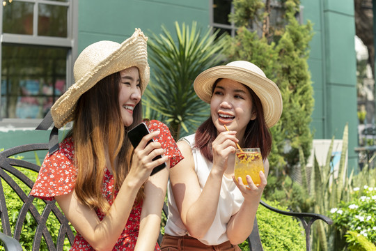两个年轻漂亮的亚洲女人在度假时戴着帽子。一起去度假。