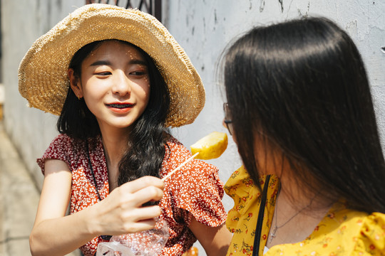 美丽的亚洲女人给她的朋友喂食。