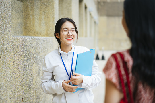 美丽的亚洲女导游与游客交谈并提供旅游信息。