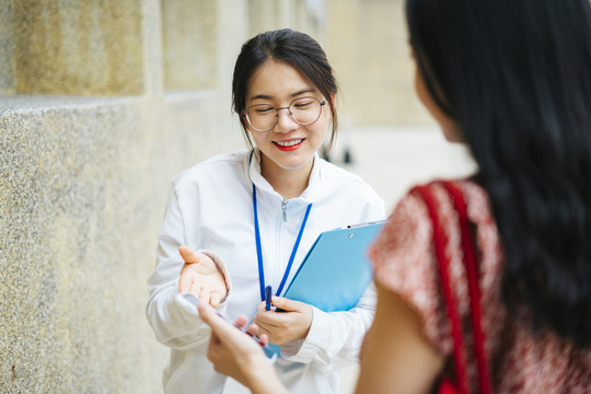 美丽的亚洲女导游与游客交谈并提供旅游信息。