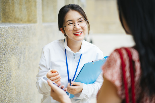 美丽的亚洲女导游与游客交谈并提供旅游信息。