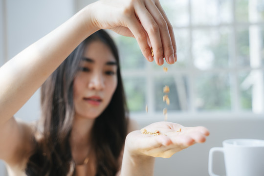 在餐厅里，一个女人手上撒了很多谷物的剪影。