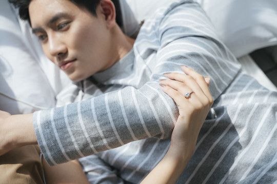 一个女人的无名指上戴着一枚戒指，而情人则一起躺在床上。