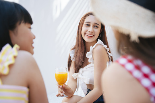 夏日派对上的性感女人和朋友们在一起。喝果汁，和人一起举杯。周末长假的夏日派对。