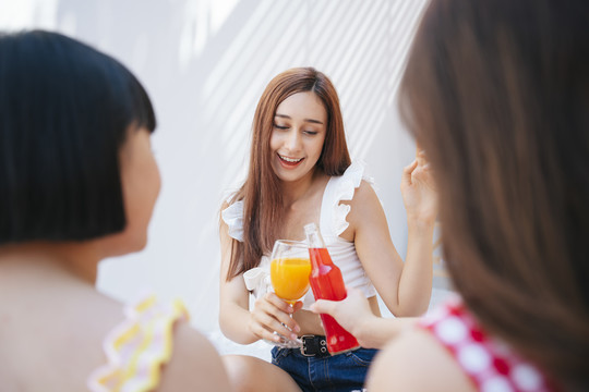 夏日派对上的性感女人和朋友们在一起。喝果汁，和人一起举杯。周末长假的夏日派对。