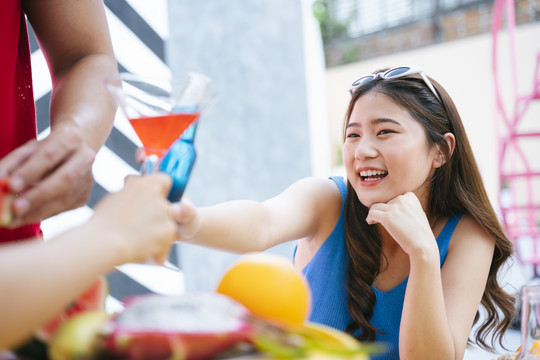 快乐的亚洲女人在夏日聚会上和人们一起举杯。