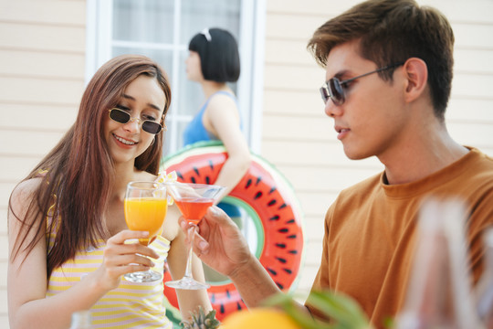 一对亚洲人在热带酒吧一起喝饮料。暑假的甜蜜时光。
