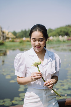 黑发女孩看着折好的白莲微笑，她为自己感到骄傲。