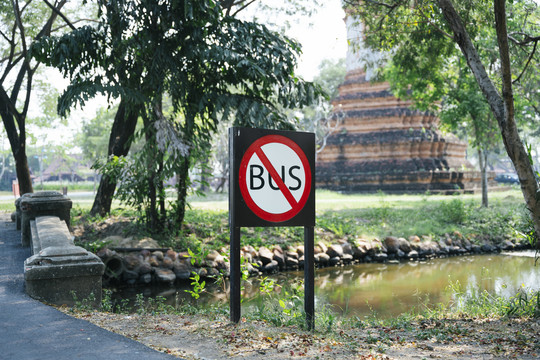 树丛中运河旁的古遗迹处禁止公共汽车进入标志的剪影。