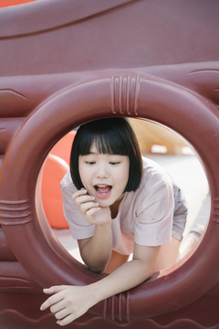 可爱的亚洲年轻女子鲍勃在操场上玩发型。椭圆形框架。闭合。