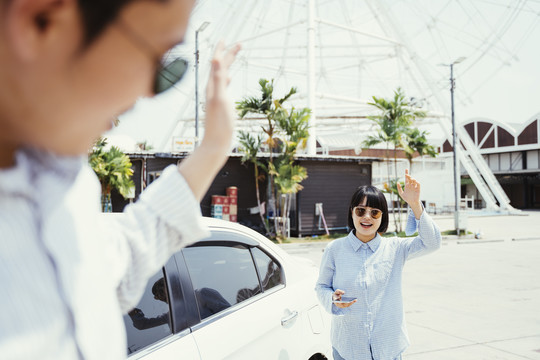 年轻的亚洲女孩在公路旅行开始前在车上遇见了她的男朋友。