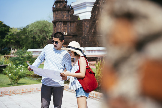 亚泰旅游夫妇使用地图和智能手机在泰国古城旅游。