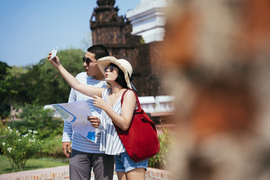 亚泰旅游夫妇使用地图和智能手机在泰国古城旅游。