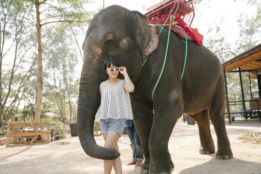 生态旅游-美丽的亚泰女人站在大象面前。
