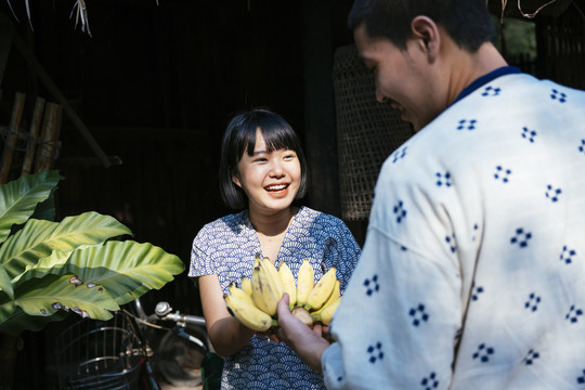 生态旅游-当地农场向顾客出售巴南。游客从可爱的卖家那里买新鲜香蕉。