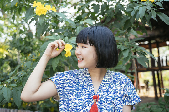 生态旅游-美丽的亚泰女子鲍勃手持黄花发型。特写镜头。