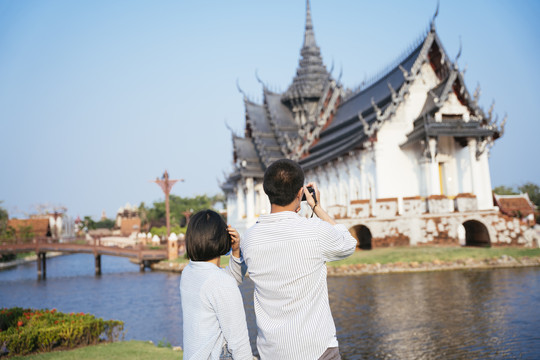 一对亚泰人喜欢用相机一起拍摄佛寺。