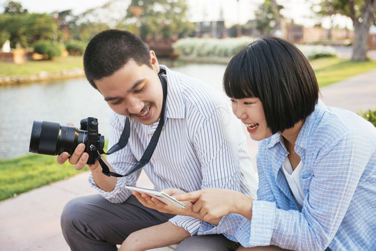 一对亚洲可爱的夫妇在镜头前看他们的照片。旅行者夫妇。