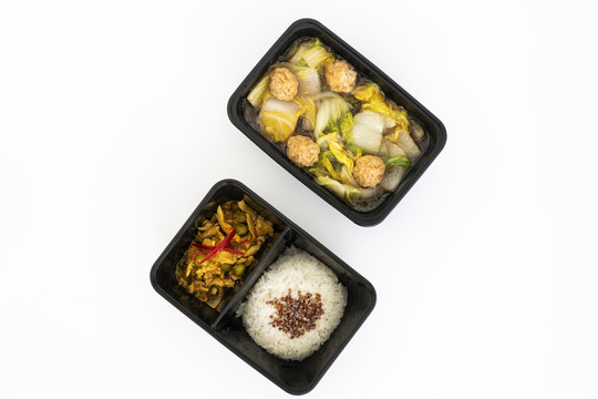 黑盒子里的辣味咖喱猪肉配米饭和肉丸蔬菜汤俯视图。用白色隔离。